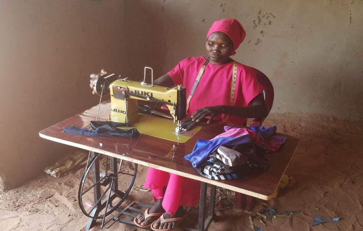 Nuba woman sewing on a sewing machine