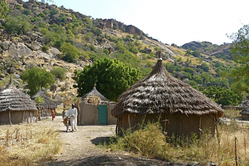 A villager in the Nuba Mountains walking a bicycle